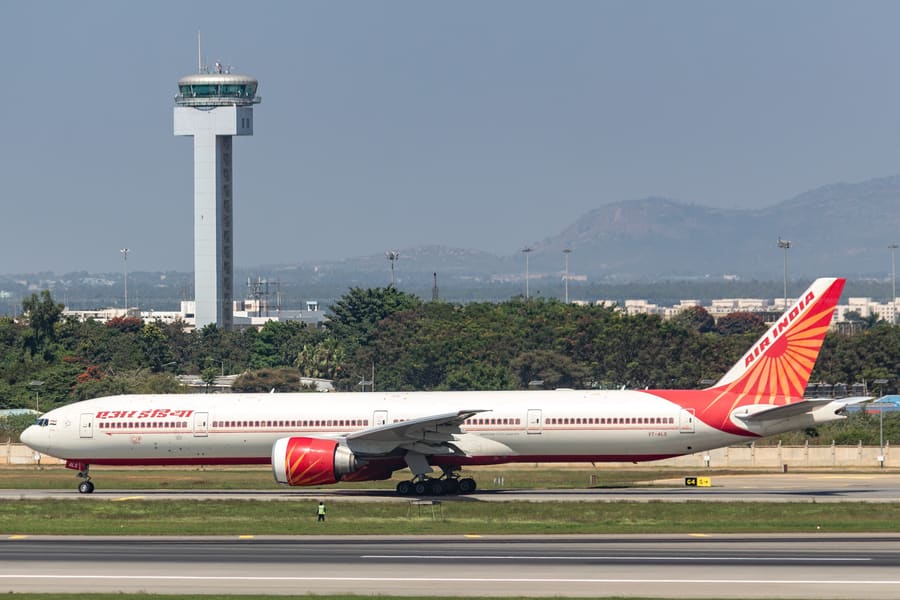 Air India 777-300ER — Tower in frame, VOBL · Bengaluru — aviation photography by Mach One Aviation